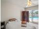 Bright bedroom with sliding glass door to pool area, ceiling fan, and privacy screen at 12300 Drake Ln, Spring Hill, FL 34609