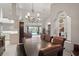 Elegant dining room with a large table, stylish chandelier, and views of the pool, perfect for entertaining guests at 12300 Drake Ln, Spring Hill, FL 34609