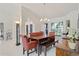 Spacious dining area with modern chandelier, views of the beautifully landscaped yard, and plenty of seating at 12300 Drake Ln, Spring Hill, FL 34609