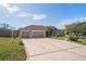 Home featuring a three car garage and decorative driveway at 12300 Drake Ln, Spring Hill, FL 34609