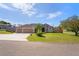 Well-maintained single-story home with a spacious three-car garage and lush green lawn at 12300 Drake Ln, Spring Hill, FL 34609