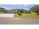 Beautiful home with a three-car garage, manicured lawn, palm tree, and decorative driveway at 12300 Drake Ln, Spring Hill, FL 34609