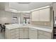 Well-lit kitchen featuring white countertops and cabinets, seamlessly connecting to the dining area at 12300 Drake Ln, Spring Hill, FL 34609