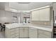 Well-lit kitchen showcasing ample counter space, white cabinets and a modern dishwasher at 12300 Drake Ln, Spring Hill, FL 34609