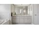 Main bathroom features double sinks, shower, toilet room, and bright lighting at 12300 Drake Ln, Spring Hill, FL 34609