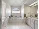 Bright main bathroom with a large soaking tub, double vanity, and separate toilet at 12300 Drake Ln, Spring Hill, FL 34609