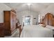 Spacious main bedroom with a decorative wooden bed frame, large wardrobe and sliding glass doors to pool at 12300 Drake Ln, Spring Hill, FL 34609
