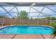 Lovely blue in-ground swimming pool with blue tile and a screened enclosure for outdoor enjoyment at 12300 Drake Ln, Spring Hill, FL 34609