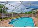 Beautiful in-ground swimming pool with blue tile and a screened enclosure for outdoor enjoyment at 12300 Drake Ln, Spring Hill, FL 34609