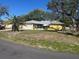 One-story yellow home with palm trees and a two-car garage at 1332 Inca Ave, Spring Hill, FL 34608