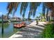 Waterfront backyard dock and canal view, shaded by palm trees on a sunny day at 13811 Michelle Ave, Hudson, FL 34667