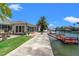 Waterfront backyard with patio seating, a dock, and lush landscaping by the canal at 13811 Michelle Ave, Hudson, FL 34667