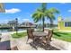 Waterfront backyard patio with seating, palm tree, and stunning canal views at 13811 Michelle Ave, Hudson, FL 34667