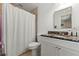 Bright bathroom features granite countertop vanity and shower/tub with white shower curtain at 13811 Michelle Ave, Hudson, FL 34667