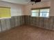 Spacious bedroom with two windows and wood-look tile flooring under renovation at 13811 Michelle Ave, Hudson, FL 34667