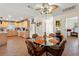 Open-concept dining area features a glass table, ceiling fan, and access to the kitchen at 13811 Michelle Ave, Hudson, FL 34667