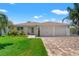 Charming single-story home with a brick driveway, a well-manicured lawn, and a two-car garage at 13811 Michelle Ave, Hudson, FL 34667