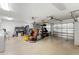 Spacious two-car garage with shelving, tools, exercise equipment, and a washing machine, offering ample storage and functionality at 13811 Michelle Ave, Hudson, FL 34667