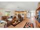Open-concept living space features tile floors, recliner chair, and access to the kitchen at 13811 Michelle Ave, Hudson, FL 34667