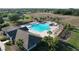 Aerial view of the community pool, clubhouse, and surrounding green spaces showcases the community's amenities at 14581 Wake Robin Dr, Brooksville, FL 34604