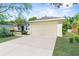 Charming home featuring a spacious driveway, a two-car garage, and well-maintained front yard at 14581 Wake Robin Dr, Brooksville, FL 34604