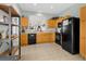 Well-lit kitchen features ample cabinetry, tile flooring and modern black appliances at 14581 Wake Robin Dr, Brooksville, FL 34604