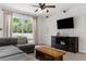 Cozy living area showcasing a plush sofa, entertainment center, and direct access to the outdoor space at 14581 Wake Robin Dr, Brooksville, FL 34604