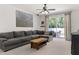 Relaxing living room featuring a large sectional sofa, natural wood coffee table, and sliding doors at 14581 Wake Robin Dr, Brooksville, FL 34604
