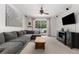 Cozy living room featuring a comfortable gray sofa, ceiling fan, and a large sliding glass door at 14581 Wake Robin Dr, Brooksville, FL 34604