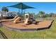 Community playground featuring mulch ground cover, slides, and swings under a blue sky at 14581 Wake Robin Dr, Brooksville, FL 34604