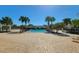 Beautiful community pool featuring palm trees, poolside seating, and a tranquil atmosphere at 14581 Wake Robin Dr, Brooksville, FL 34604
