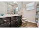Well-lit bathroom featuring a dark vanity, a large mirror, and a shower with tiled walls at 15912 42Nd E Gln, Parrish, FL 34219