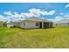 Exterior view showcasing the backyard, well-manicured lawn, and screened-in patio at 15912 42Nd E Gln, Parrish, FL 34219