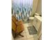 Modest bathroom featuring a forest-themed shower curtain, a toilet, and a single sink with vanity storage at 1704 Winn Arthur Dr, Valrico, FL 33594
