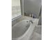 Bathroom featuring an elevated tub with tiled enclosure and frosted glass shower doors at 1704 Winn Arthur Dr, Valrico, FL 33594
