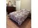 Comfortable bedroom with laminate wood flooring, a double closet, and a cozy bed with a patterned comforter at 1704 Winn Arthur Dr, Valrico, FL 33594