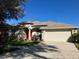 Charming single-story home with a well-manicured lawn, a two-car garage, and an eye-catching red front door at 1704 Winn Arthur Dr, Valrico, FL 33594