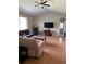 Open living room boasting a ceiling fan, TV, and archway, complemented by laminate wood flooring for a modern touch at 1704 Winn Arthur Dr, Valrico, FL 33594