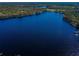 Scenic aerial view of a calm, deep lake surrounded by lush greenery, offering a serene escape at 18725 Jiretz Rd, Odessa, FL 33556