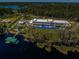 Aerial view of modern home, lake access, including a dock, in a private wooded community at 18725 Jiretz Rd, Odessa, FL 33556