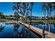 Backyard view from the lake featuring large home and covered seating area at 18725 Jiretz Rd, Odessa, FL 33556
