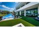 Expansive backyard with a pool, well-maintained lawn, and a modern home facade at 18725 Jiretz Rd, Odessa, FL 33556