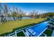 Picturesque backyard with a large pool, manicured lawn, and lake views, ideal for relaxation at 18725 Jiretz Rd, Odessa, FL 33556
