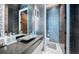 Contemporary bathroom featuring elegant fixtures, unique geometric backsplash, and wood door at 18725 Jiretz Rd, Odessa, FL 33556