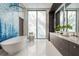 Modern bathroom features a standalone tub with blue tile accent wall, dual sink vanity, and sleek finishes at 18725 Jiretz Rd, Odessa, FL 33556