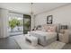 Serene bedroom with plush bedding, stylish chandelier, and large sliding doors leading to a balcony with lake views at 18725 Jiretz Rd, Odessa, FL 33556