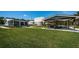 Expansive lawn view showing a covered outdoor eating area and the exterior of the main house at 18725 Jiretz Rd, Odessa, FL 33556