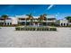 Striking modern home exterior, featuring a grand entrance with a water feature, palm trees, and a spacious paved driveway at 18725 Jiretz Rd, Odessa, FL 33556