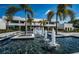 Contemporary home featuring a striking water feature, palm trees, and a modern design on a sunny day at 18725 Jiretz Rd, Odessa, FL 33556