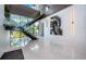 Stunning foyer showcasing a modern staircase, polished floors, and floor-to-ceiling windows with lush outdoor views at 18725 Jiretz Rd, Odessa, FL 33556
